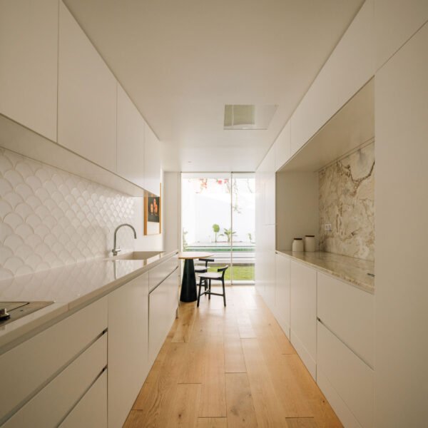 To create a contrast with the main façade, the back elevation was designed and punctuated by a series of windows and shutters, forming a pattern inspired by traditional Portuguese fish scale tiles. This pattern acts as a dynamic skin that filters sunlight, ensures privacy, and serves as a protective barrier against intruders. The aim was to design a sophisticated and harmonious contemporary home which blended modern functionality with mid-20th-century charm, offering a perfect balance of comfort, style, and practicality.