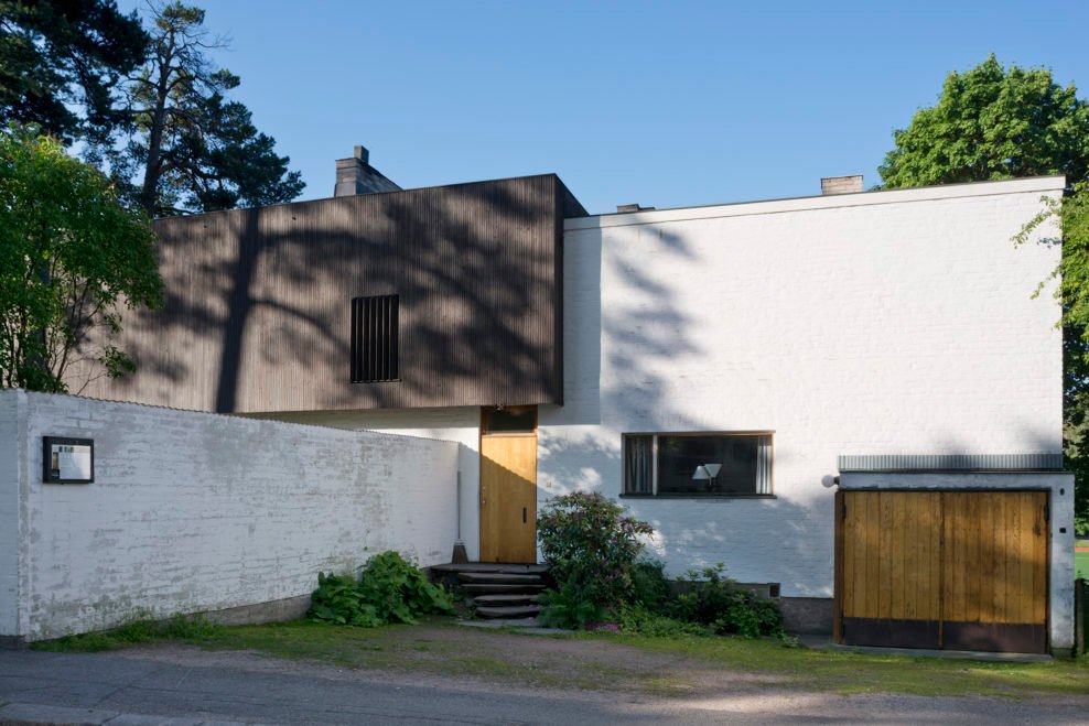 Fachada de la Casa Aalto entre la vegetación de su jardín en Helsinki.
