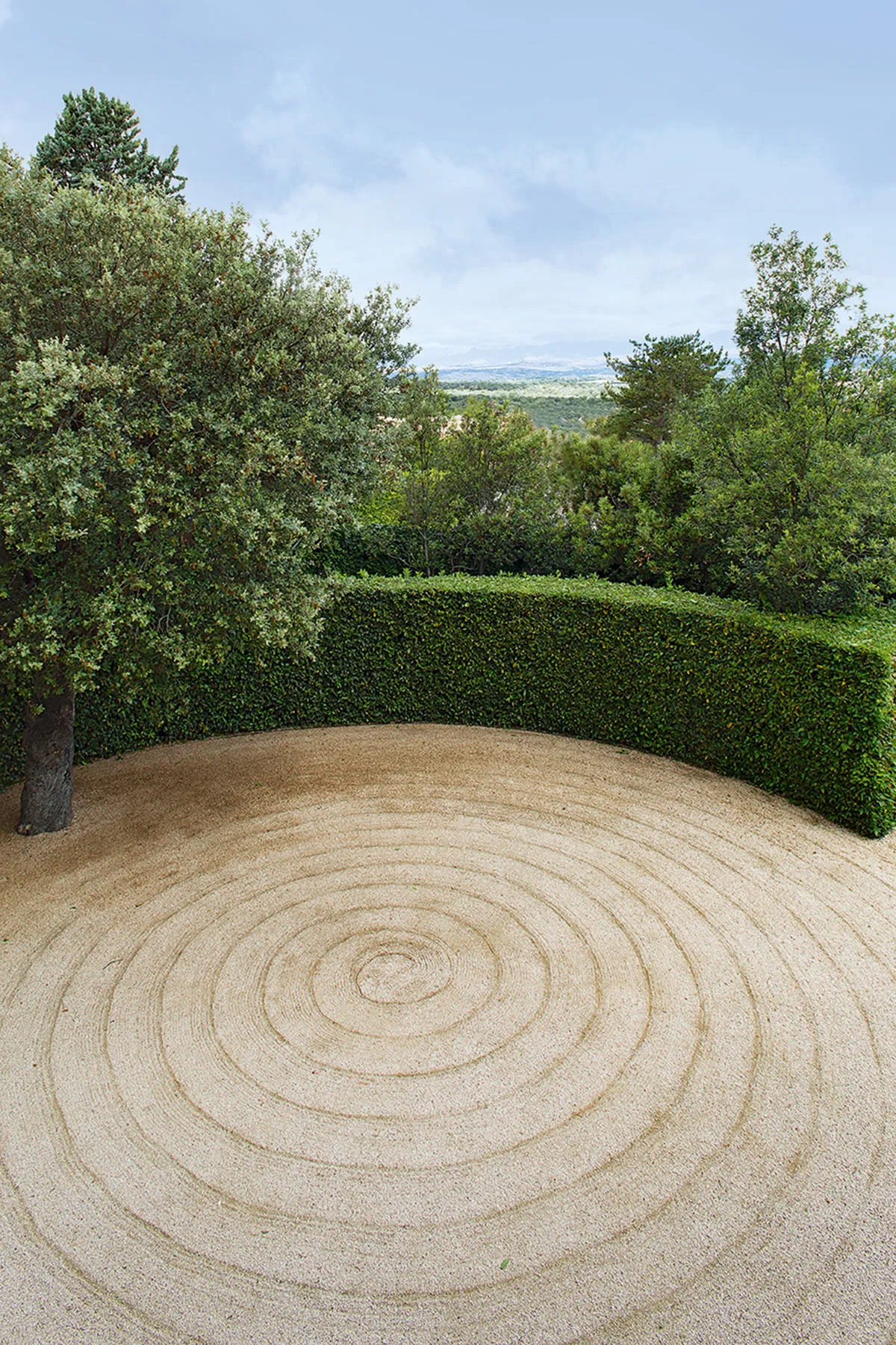 Jard&iacute;n de Fernando Caruncho con espiral trazada sobre grava y vegetaci&oacute;n