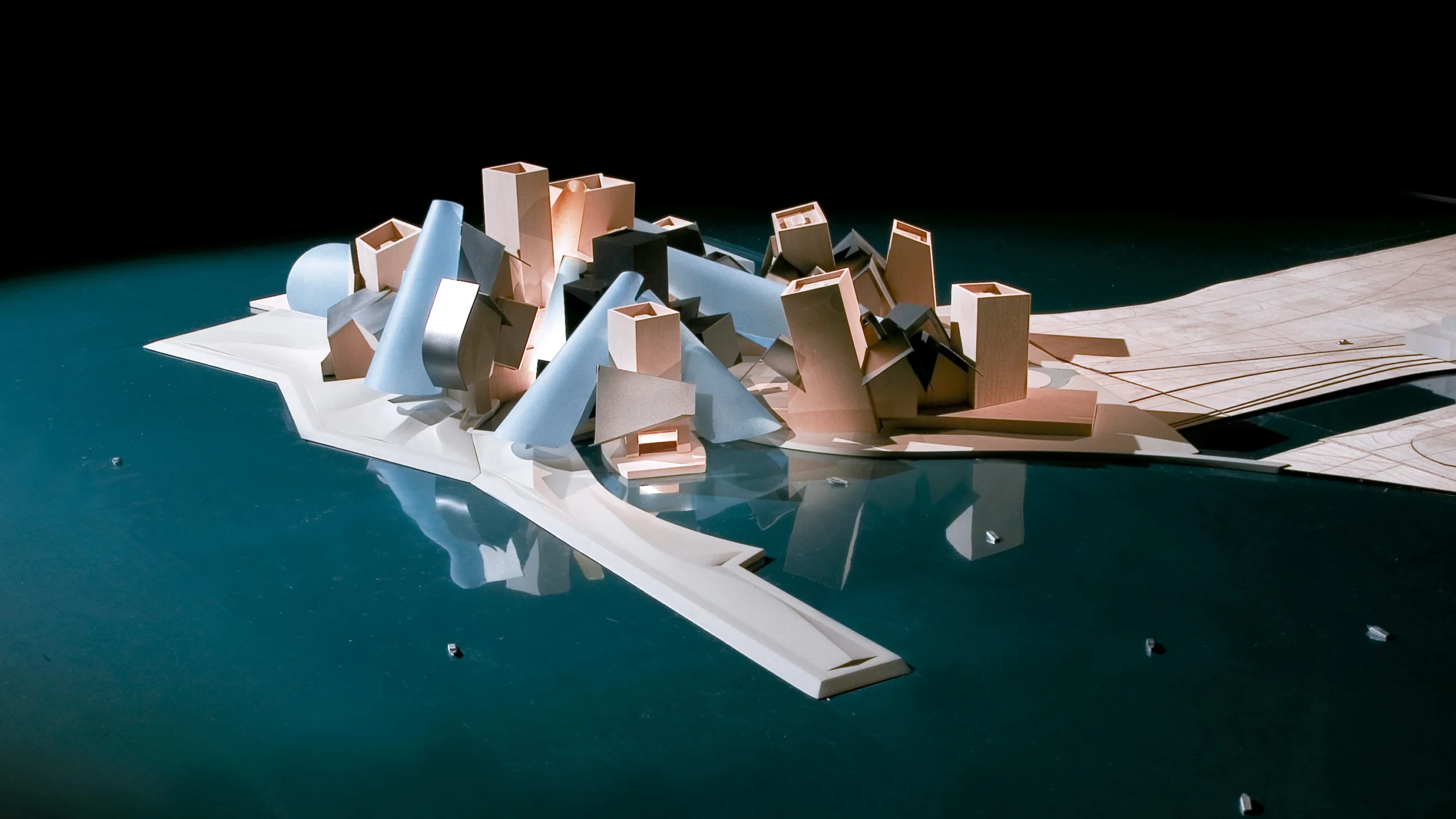Maqueta del Guggenheim Abu Dhabi de Frank Gehry mostrando sus volúmenes, conos y relación con el agua