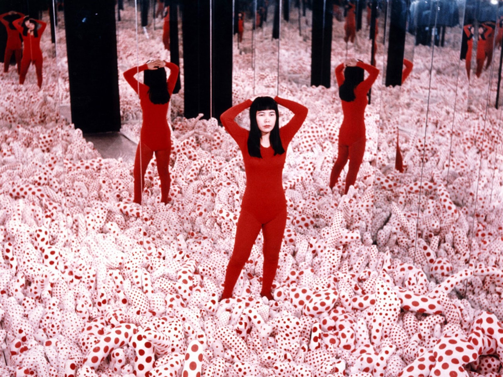 Yayoi Kusama en Infinity Mirror Room&mdash;Phalli&rsquo;s Field rodeada de esculturas blancas con lunares rojos y espejos