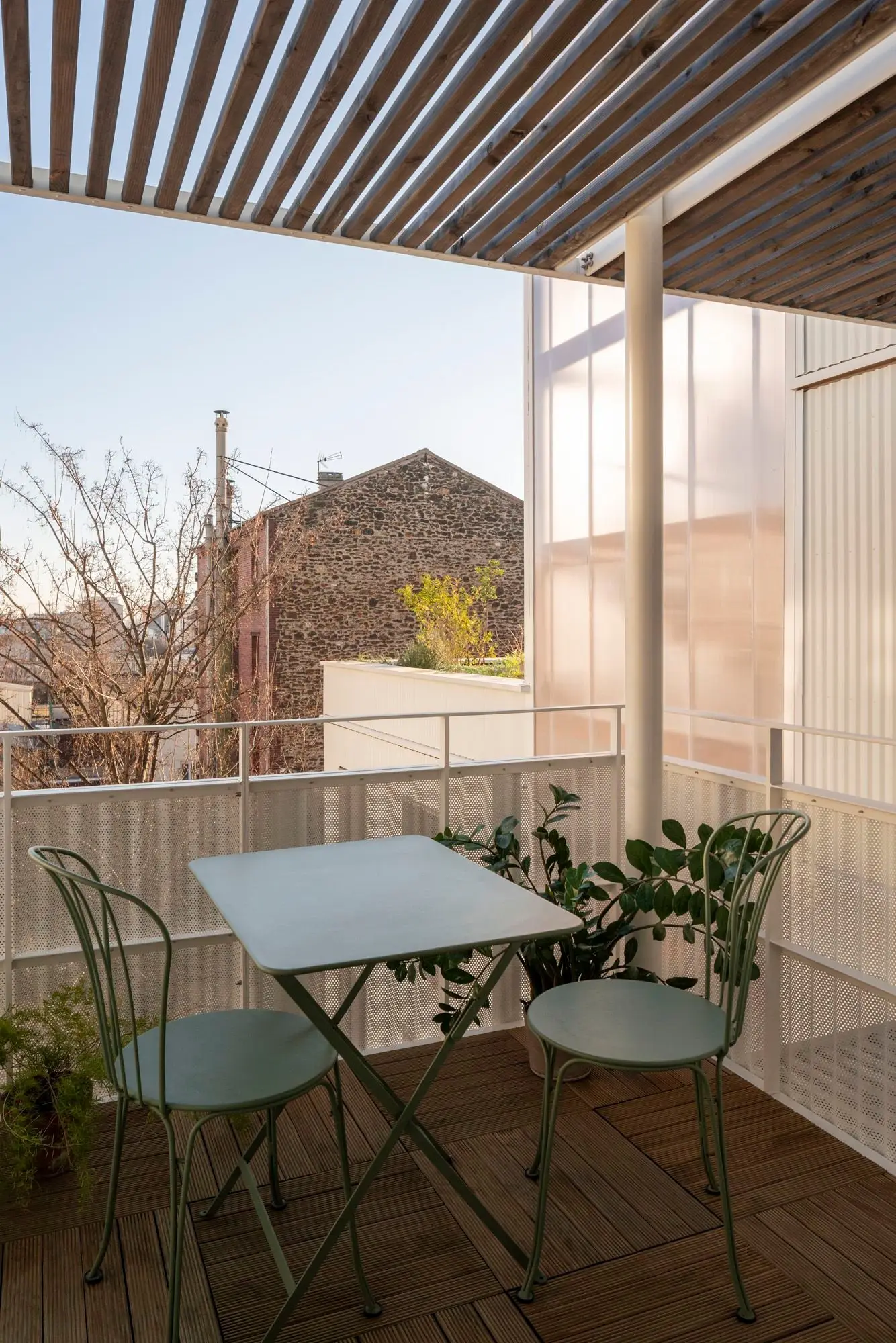 Terraza privada con mesa y p&eacute;rgola de madera