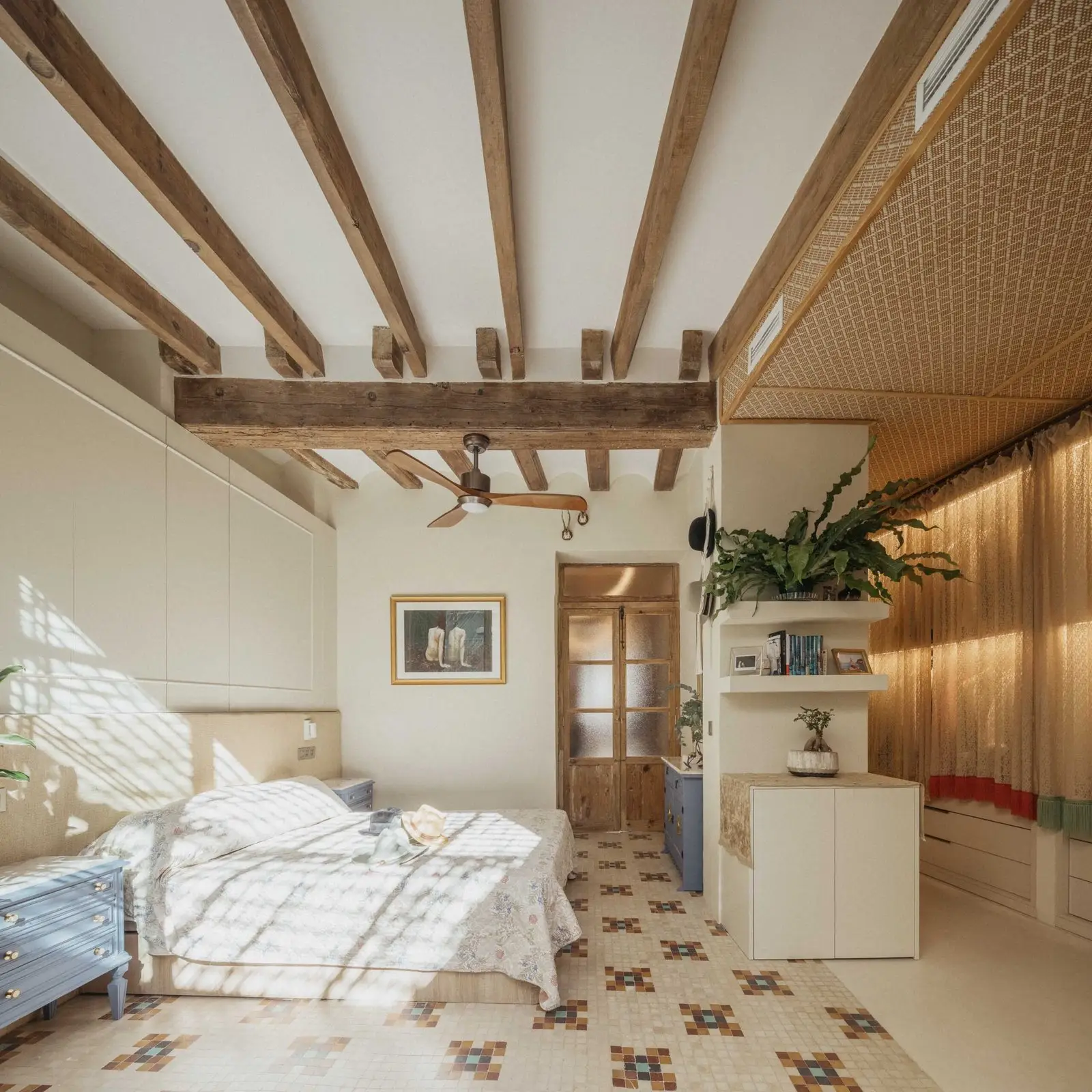 Dormitorio con vigas de madera y pavimento original recuperado de Casa Ángel en Ruzafa