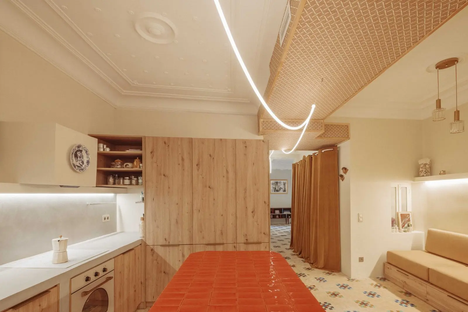 Cocina con isla roja e iluminación suspendida de Casa Ángel en Ruzafa