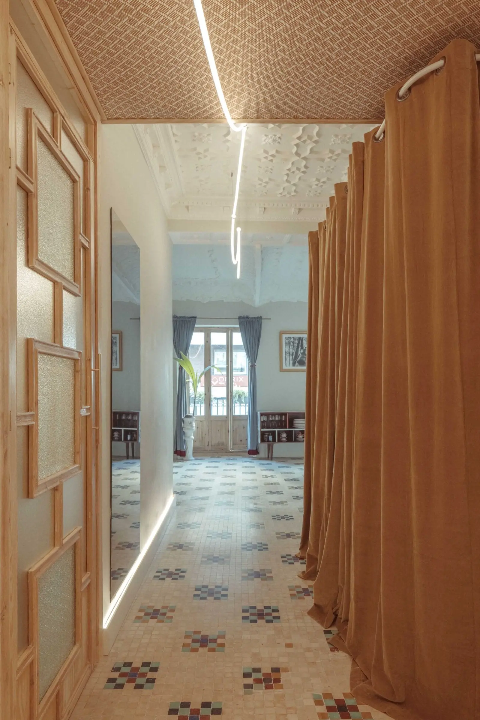 Pasillo con cortinas y luz lineal de Casa Ángel en Ruzafa