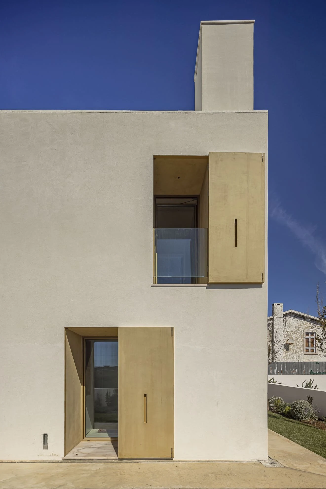 Esquina de la vivienda con ventanas y contraventanas abiertas de Casa CC, de Esquissos