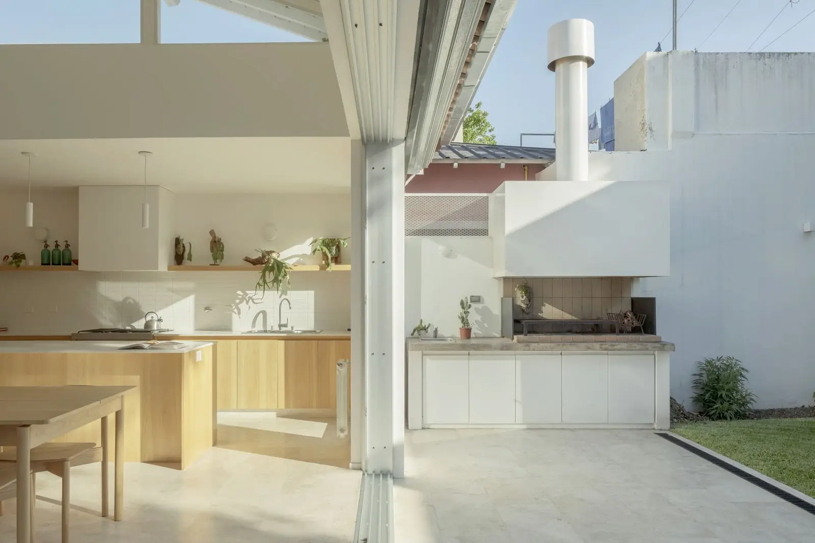 Continuidad entre la cocina y la parrilla exterior de Casa Florida, de Di Marco + Robles Arquitectos