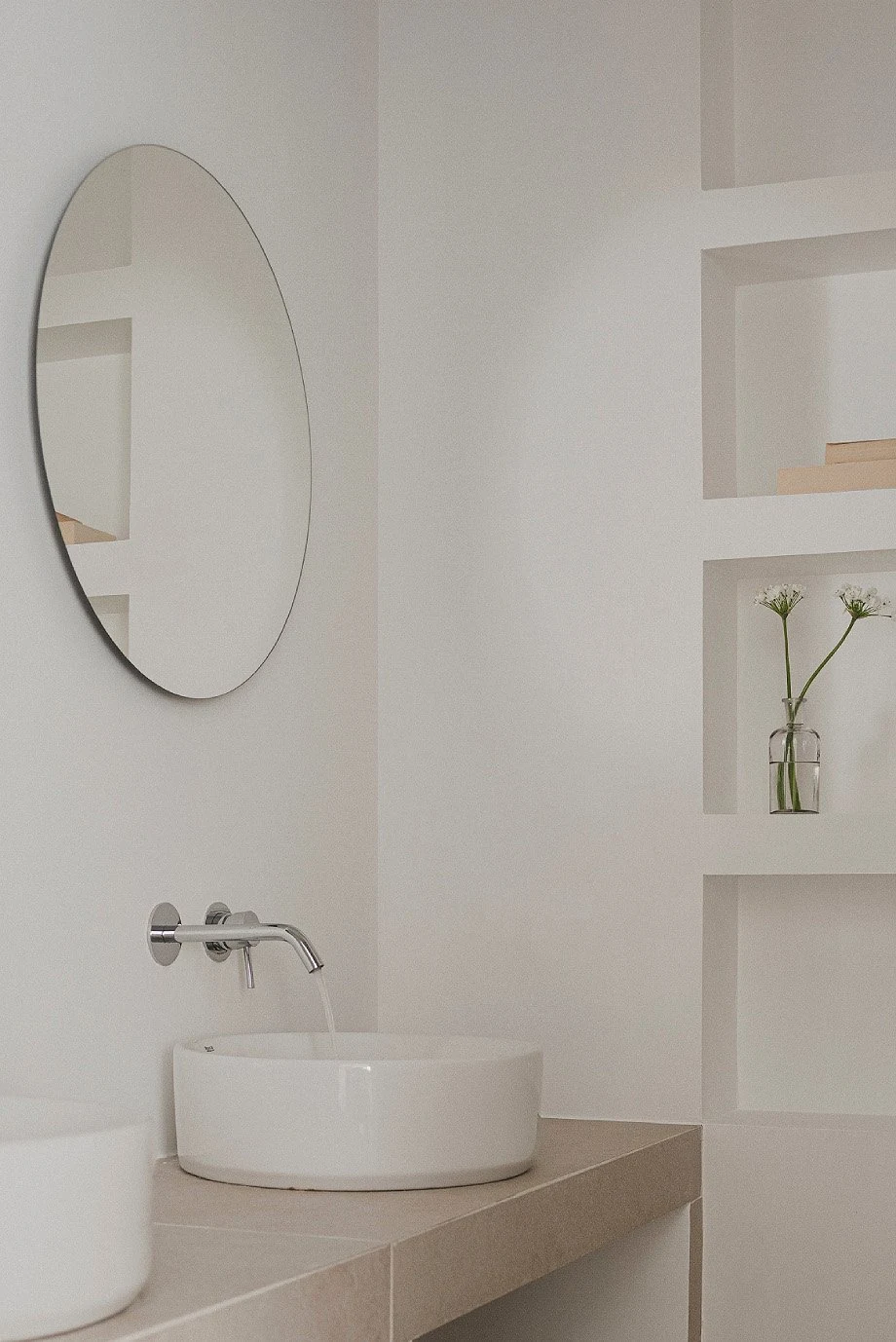 Ba&ntilde;o con lavabo y espejo circular de Casa ML, de Maximale