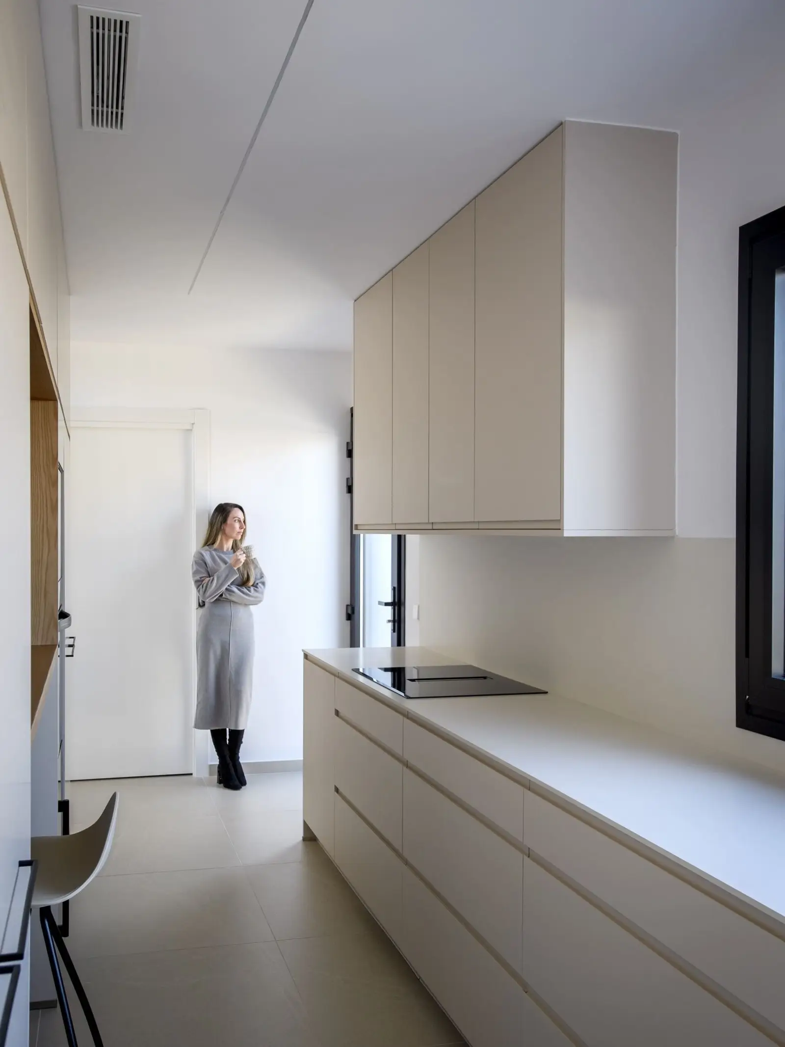 Cocina longitudinal iluminada con luz natural de Casa Olivera, de Miragall Romaguera i arquitectes associats