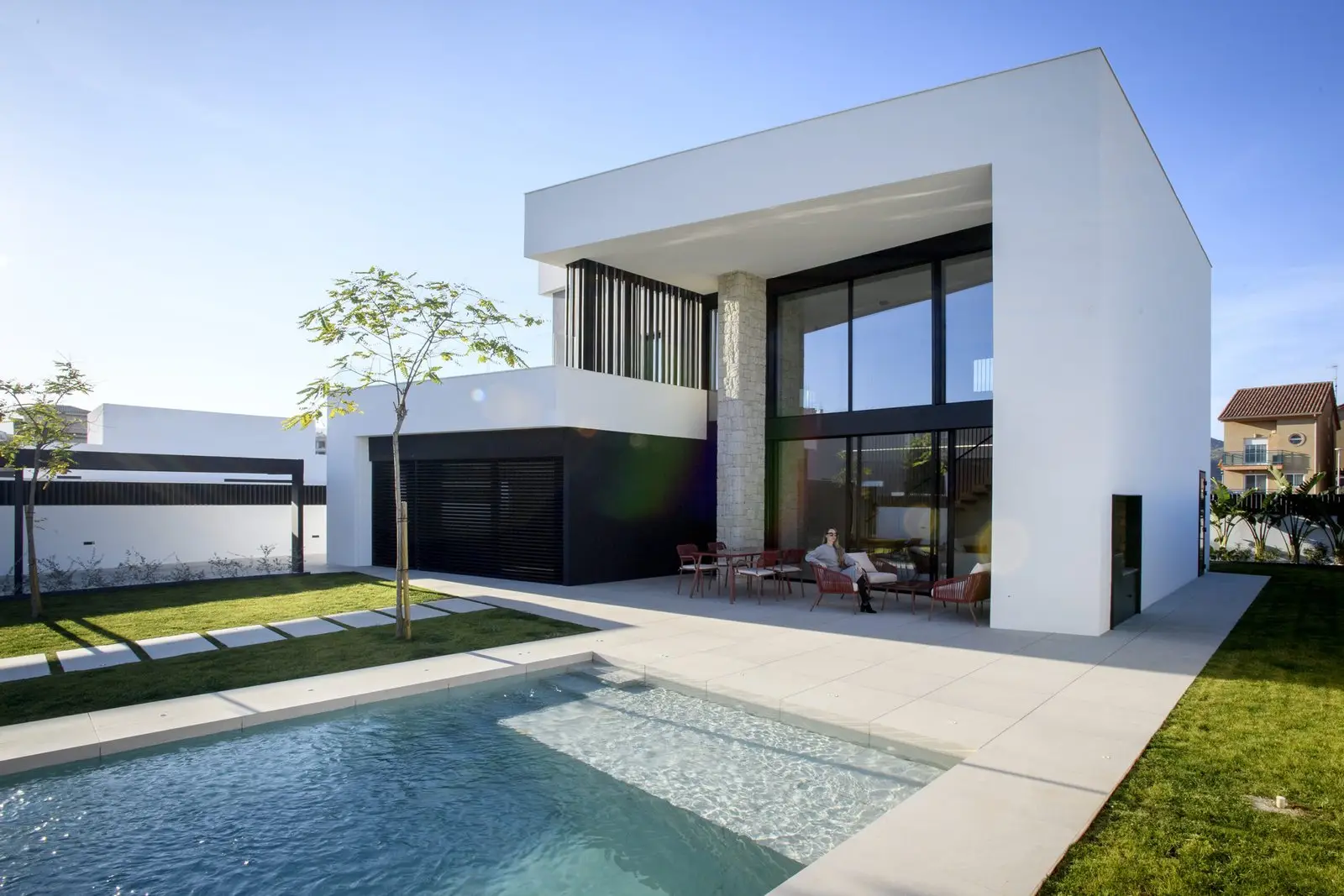 Fachada diurna con porche, jardín y piscina de Casa Olivera, de Miragall Romaguera i arquitectes associats