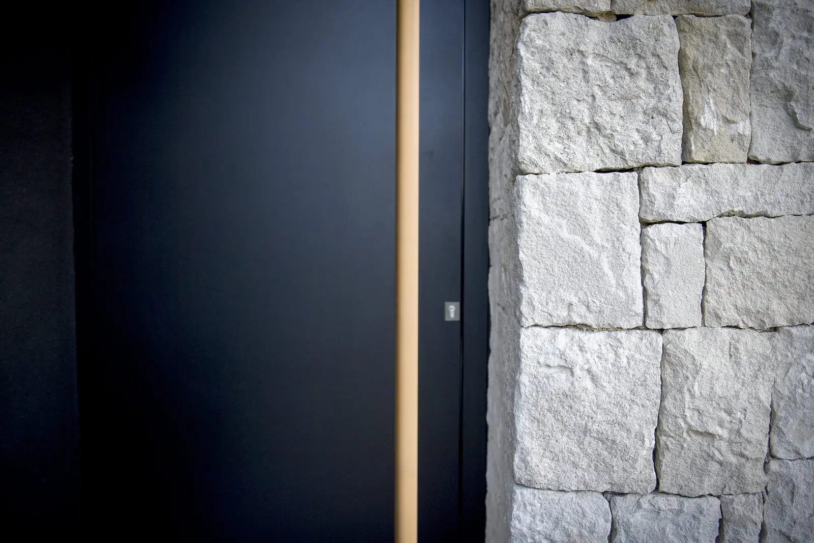 Detalle de la puerta de acceso y el muro de piedra de Casa Olivera, de Miragall Romaguera i arquitectes associats
