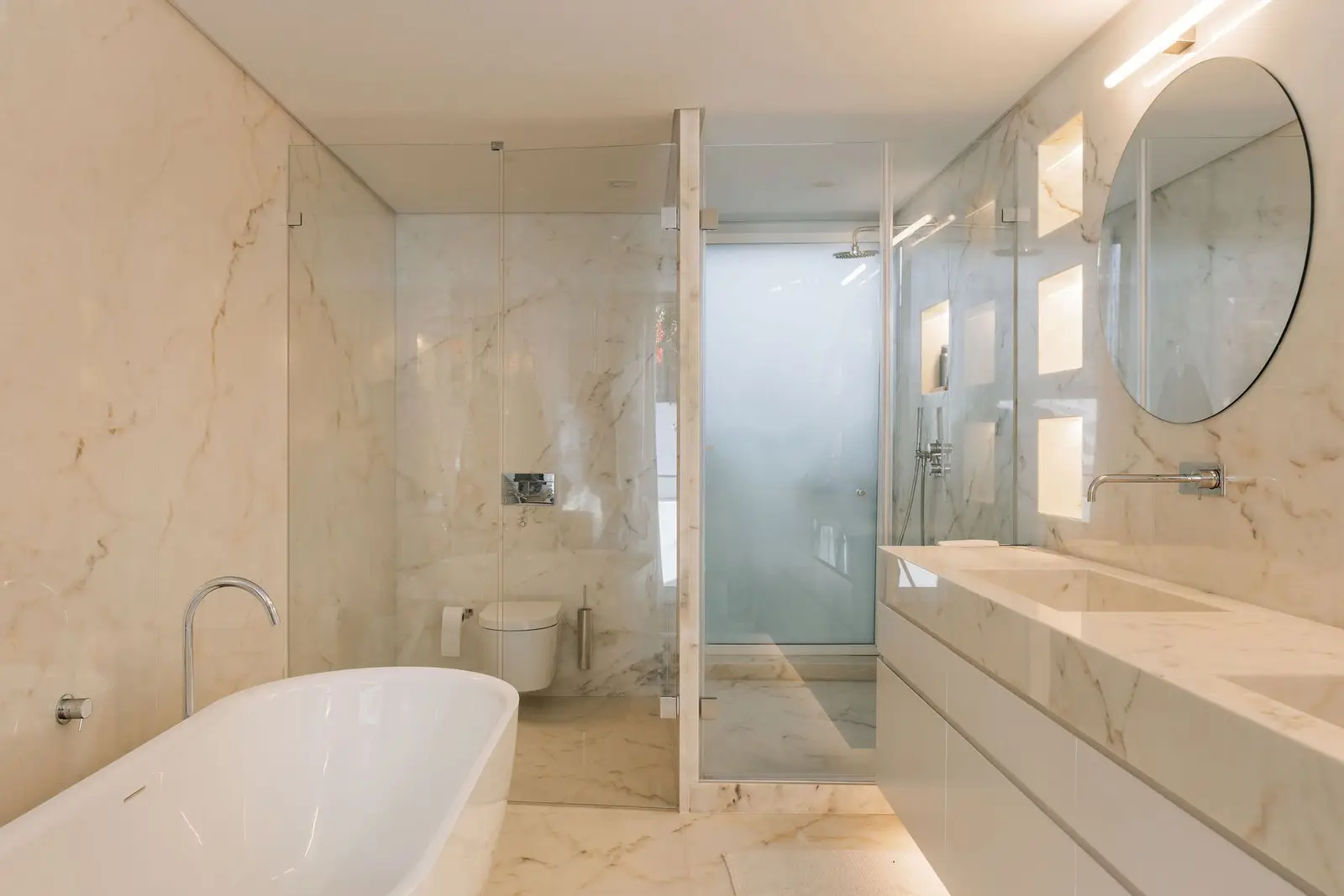 Ba&ntilde;o de piedra natural con ba&ntilde;era exenta e iluminaci&oacute;n integrada