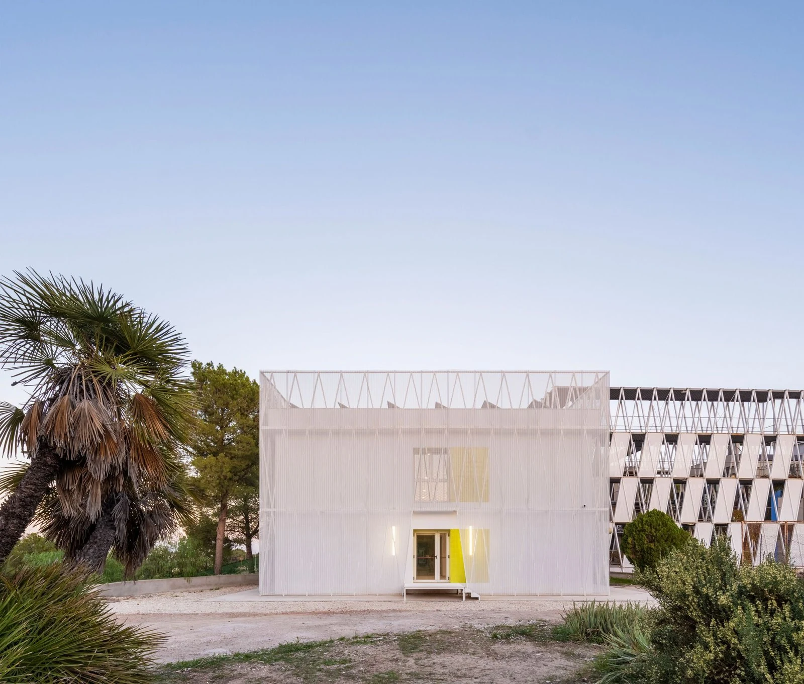 Fachada principal al atardecer de Edificio Q en el Parque Científico de Murcia, de COR Architecture + Design