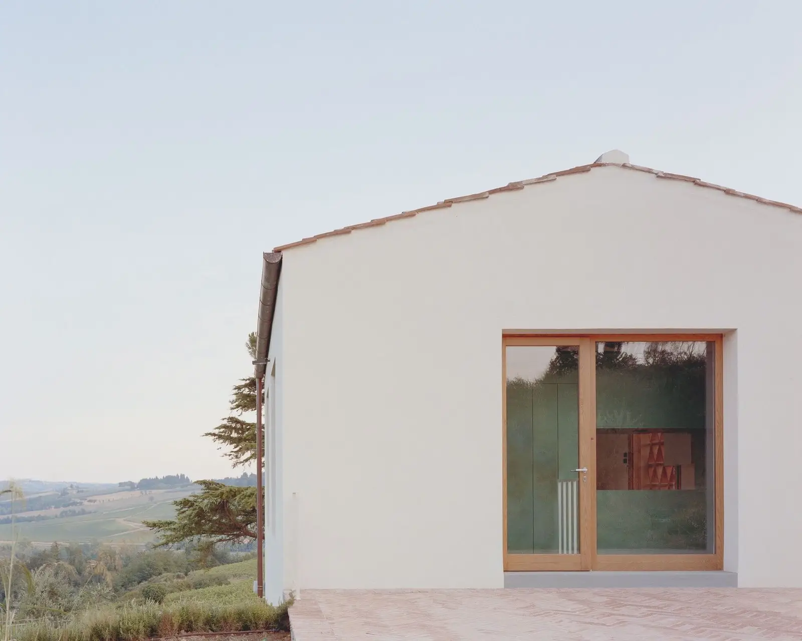 Fachada blanca del Granero Fienile N abierta al paisaje de la campiña florentina