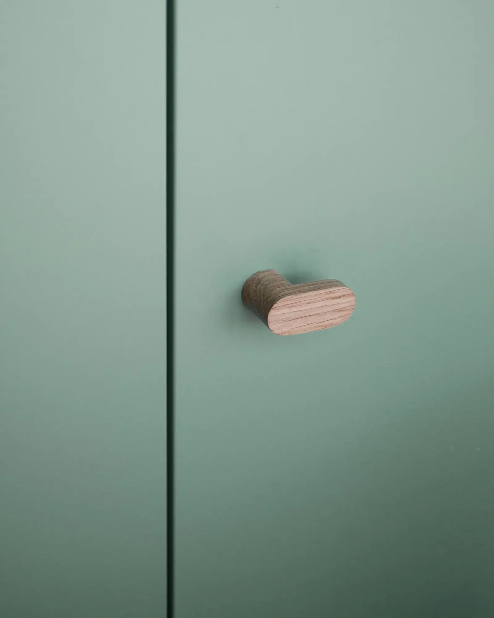 Detalle del tirador de madera en el mueble verde de Fienile N