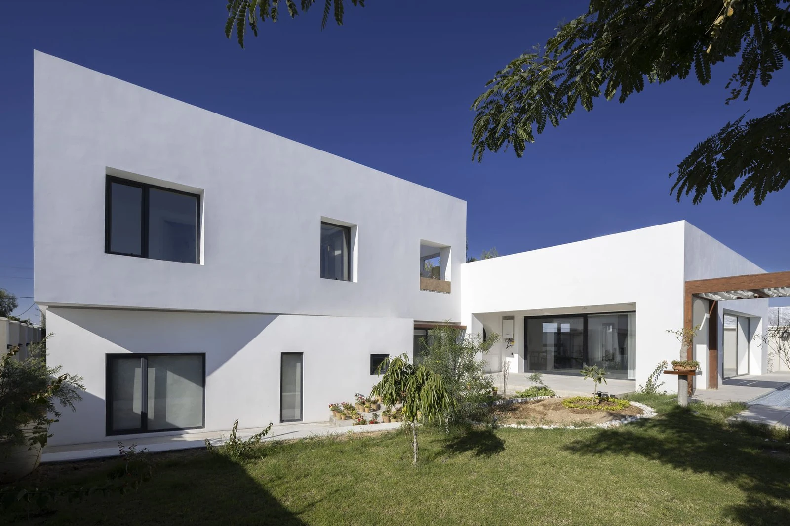 Volúmenes blancos de la villa abiertos al jardín de Villa 144, de Lin3rd Architects