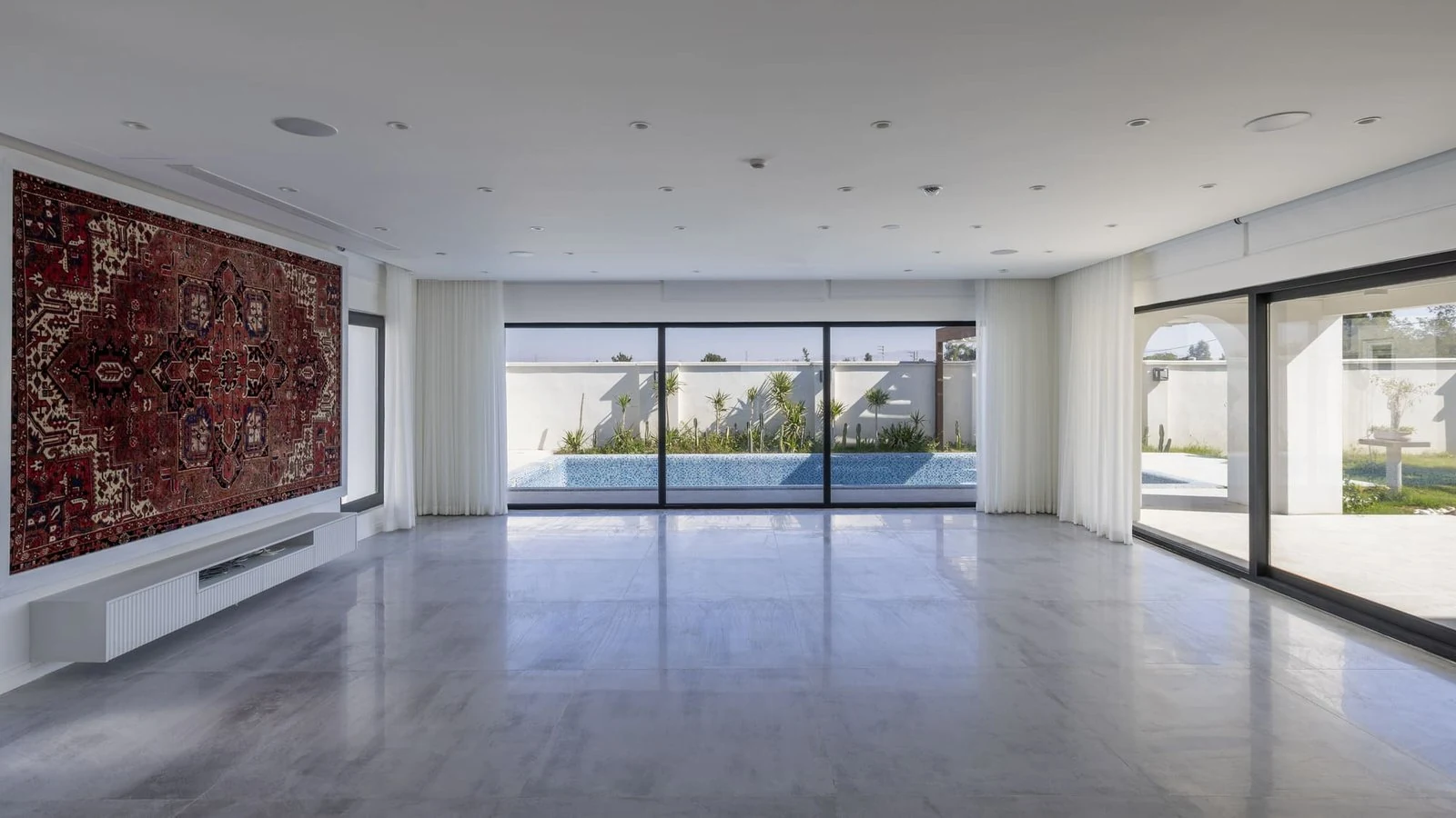 Sal&oacute;n con alfombra persa expuesta en la pared de Villa 144, de Lin3rd Architects