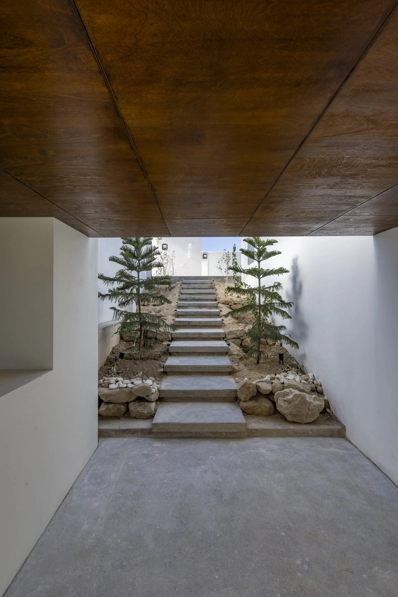 Recorrido cubierto de acceso con escalera exterior de Villa 144, de Lin3rd Architects